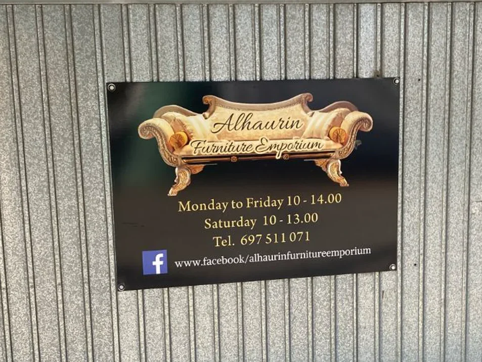 Before: the old printed sign of Alhaurín Furniture Emporium on the shop garage door