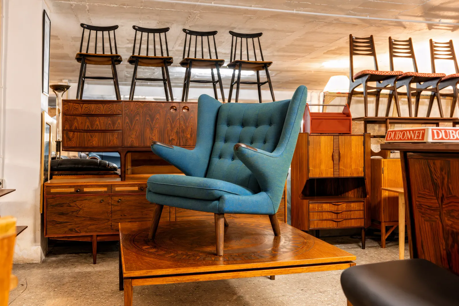 Brand shoot: a blue mid-century armchair among teak furniture at Alhaurín Furniture Emporium