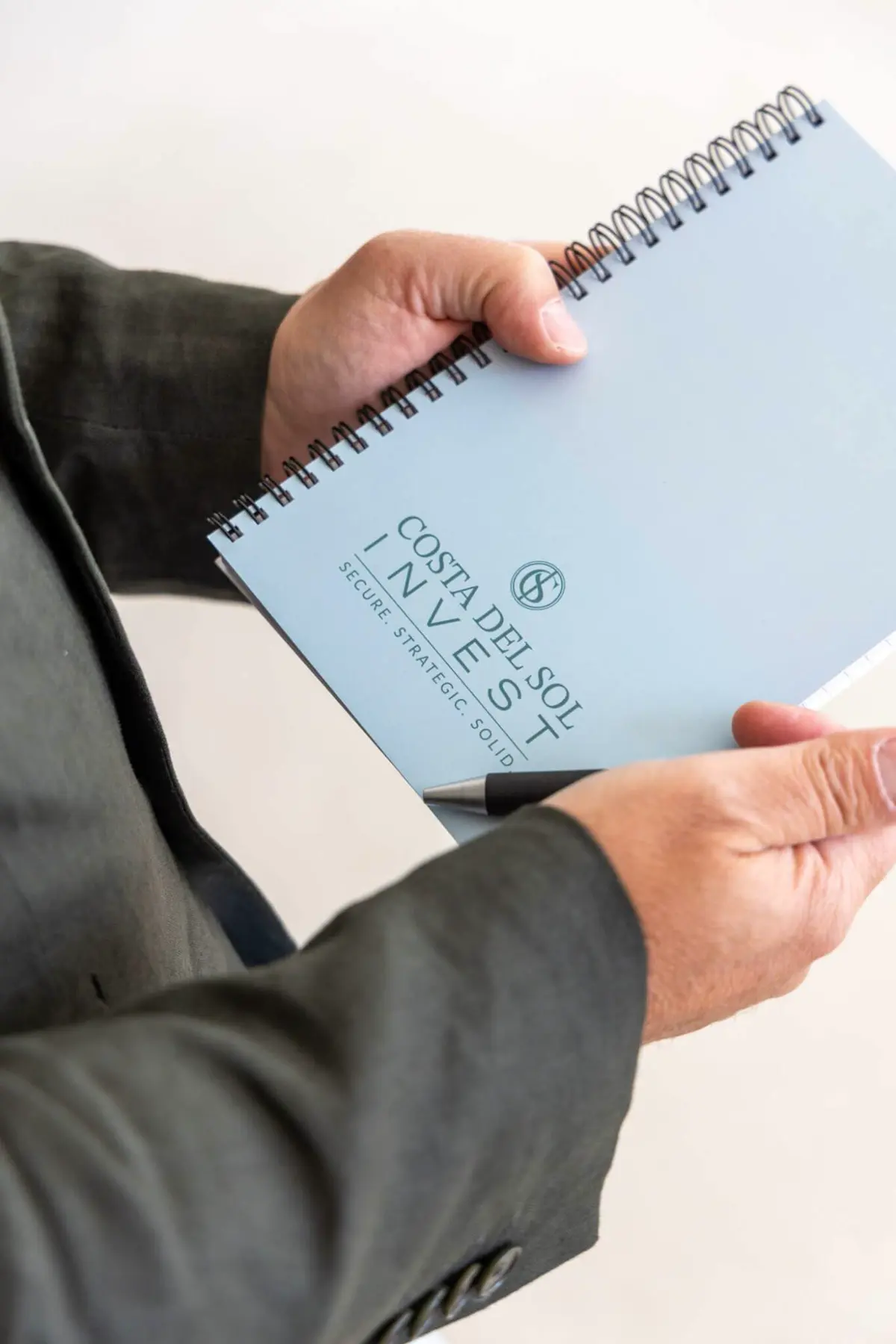 Brand shoot: holding a Costa del Sol Invest notebook